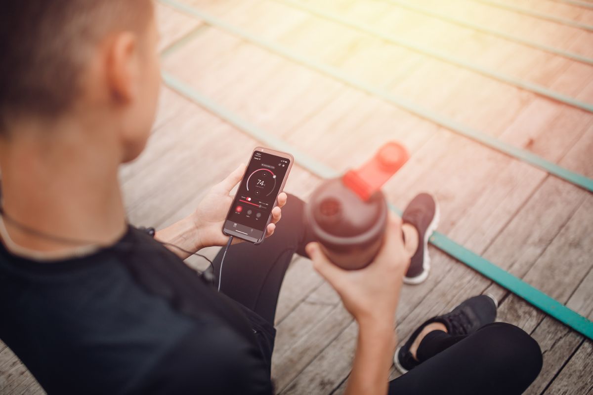 idrottare som håller en vattenflaska och telefon