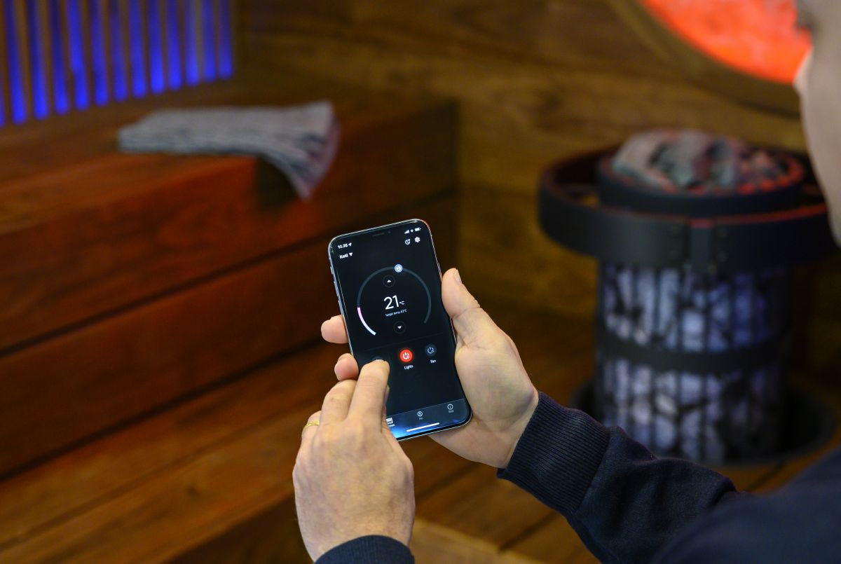 person som styr bastuutrustningen med mobilappen MyHarvia