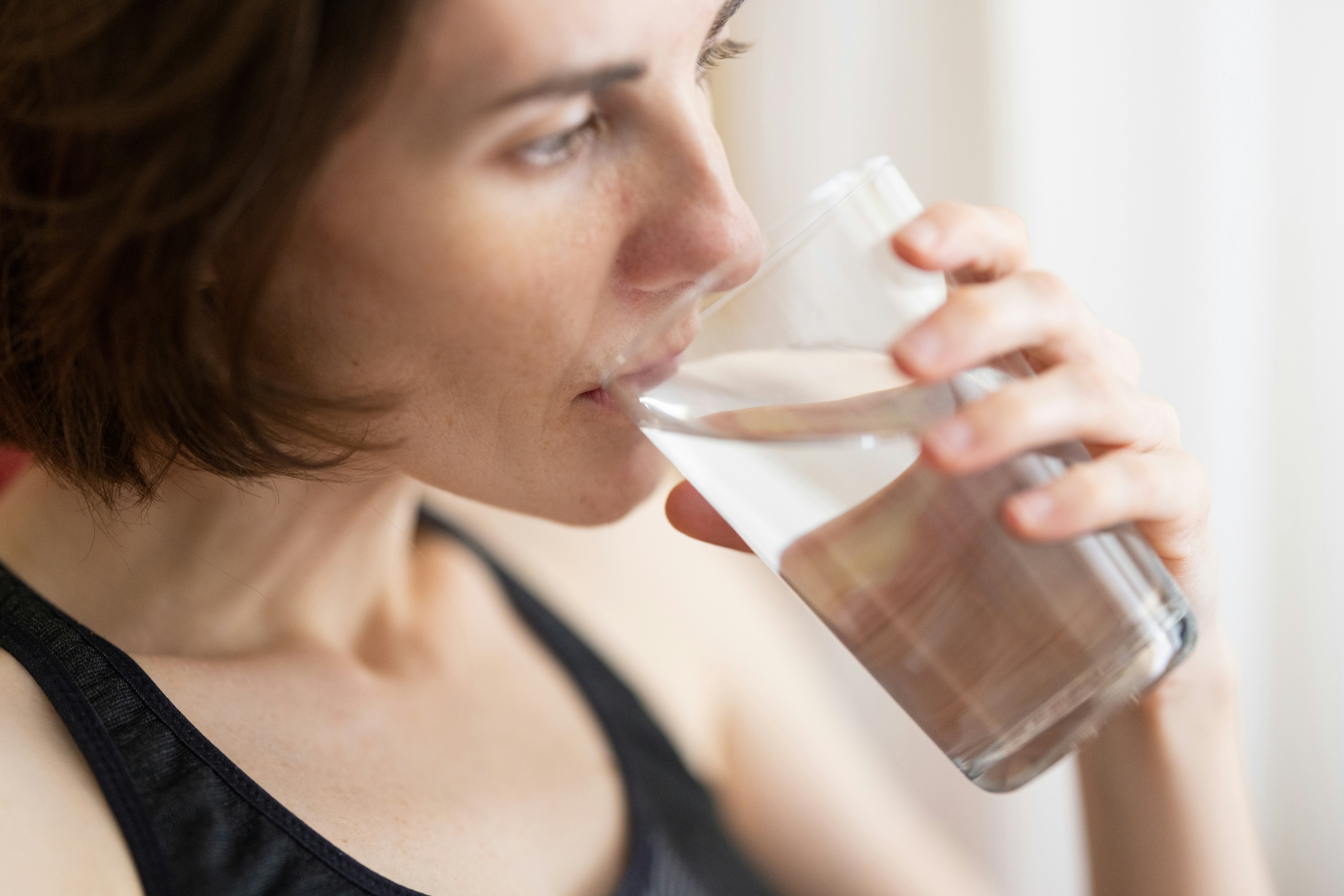 Flicka dricker ett glas vatten